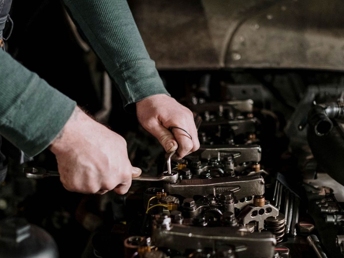 Mechanic using hand tools to repair a car engine