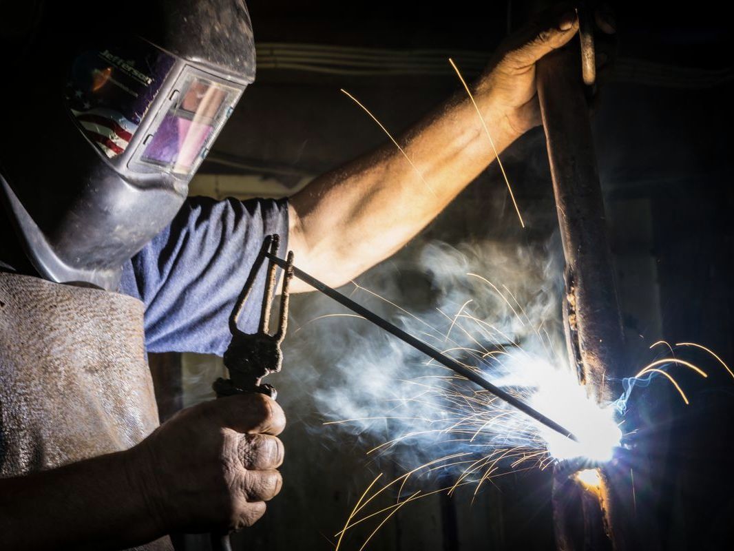 Welder striking an arc, sparks flying from the joint